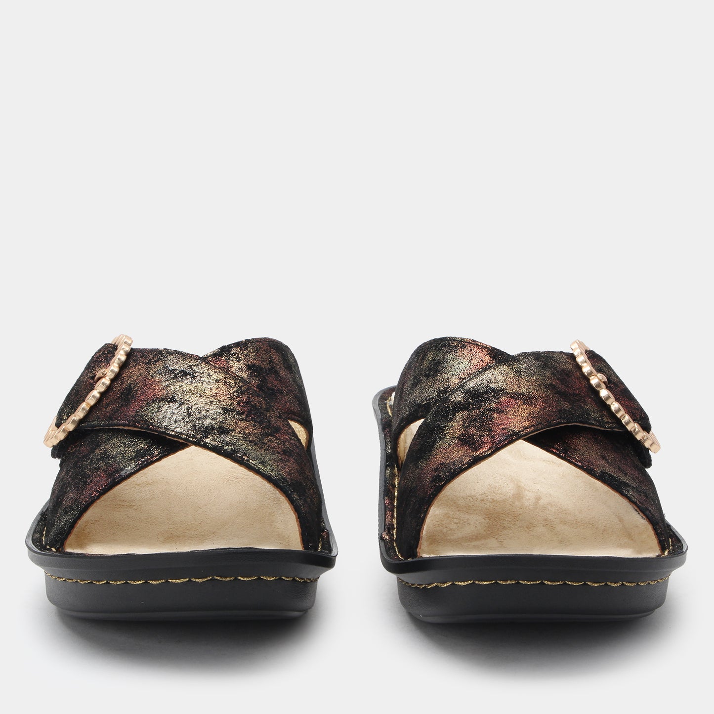 Pair of black and gold sandals with pearl embellishments on a white background